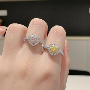 Gros plan de bagues coeur roses et jaunes avec halo de diamants sur argent S925