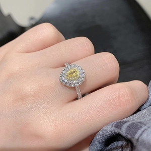 Detailed view of luxury sterling silver ring with yellow pear-cut zircon and halo stones