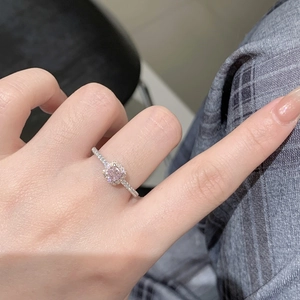 Close-up of S925 sterling silver ring with square pink stone and halo diamond setting