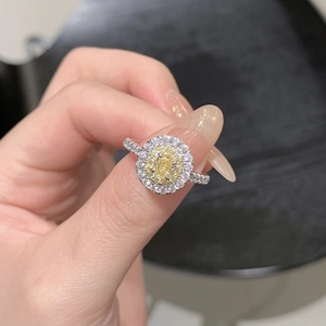 Close-up of halo ring with oval yellow stone and double rows of brilliant white zircon