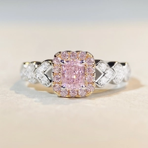 Macro d'une bague avec gemme rose et diamants halo sur anneau en argent avec cœurs