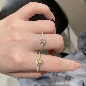 Macro detail of hand-worn S925 silver rings with pink and yellow cushion-cut halo stones