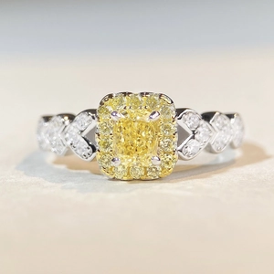 Vue macro d'une bague diamant jaune taille coussin avec anneau serti de diamants en V