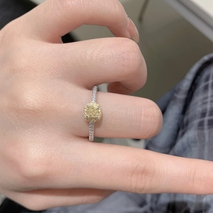 Dettaglio anello di lusso con pietra gialla taglio cushion e montatura halo argento