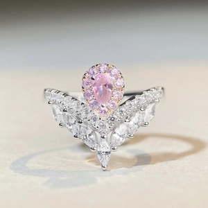 Detailed macro view of S925 silver V-shaped ring with pink pear-cut stone and tiny diamonds