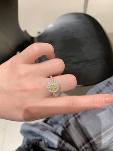 Detail of sterling silver ring with oval yellow gemstone and shimmering pavé zircons