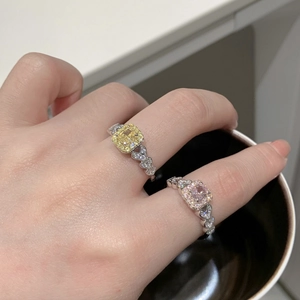Gros plan de bagues en argent S925 avec pierres carrées jaunes et roses et motifs de cœur