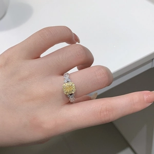 Detailed close-up of a cushion-cut yellow diamond ring with heart-shaped pave accents