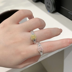 Gros plan de bagues en argent S925 avec diamants jaune et rose taille coussin sur un doigt
