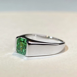 Men's S925 silver ring with emerald-cut green stone on a polished band