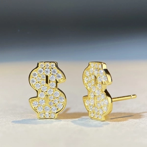 Gros plan de boucles d'oreilles dollar dorées serties de pierres de moissanite rondes