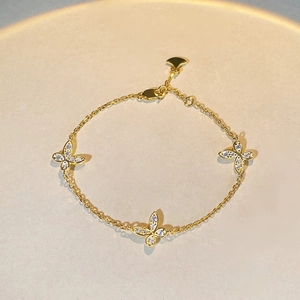 Elegantes goldenes Schmetterlingsarmband mit glitzernden Steinen im Sunset-Design