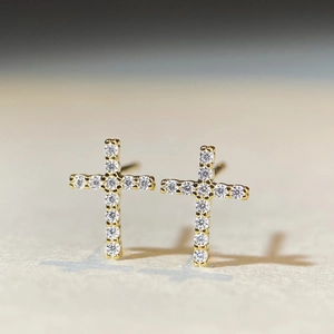 Vue macro de boucles d'oreilles croix en argent avec pierres moissanite pavées