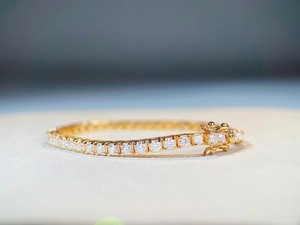 Dettaglio ravvicinato del bracciale tennis in moissanite dorata con chiusura a doppia scatola