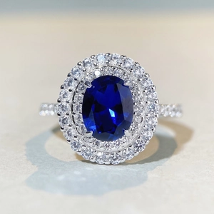 Vue macro d'une bague en argent S925 avec saphir bleu ovale et double entourage diamants