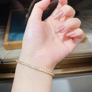 Primo piano di un bracciale tennis in argento S925 dorato da 2,5 mm con moissanite al polso