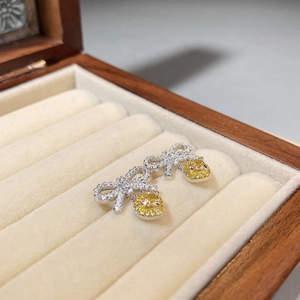 S925 silver bow stud earrings with yellow cushion-cut gemstones in a wooden gift box
