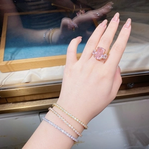 Dettaglio di un anello con gemma rosa e tre braccialetti tennis con diamanti colorati