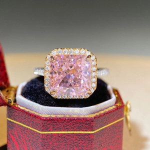 Detailed macro view of a pink cushion-cut gem ring set in a red luxury velvet box