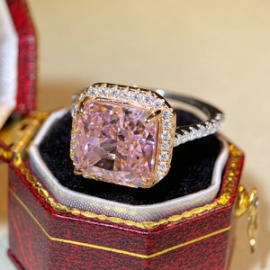 Detailed shot of radiant cut pink zircon ring in a red jewelry box with halo setting