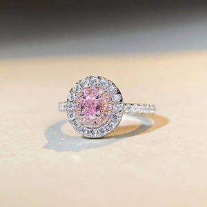 Detailed close-up of double halo pink oval gemstone ring with pavé-set diamond band