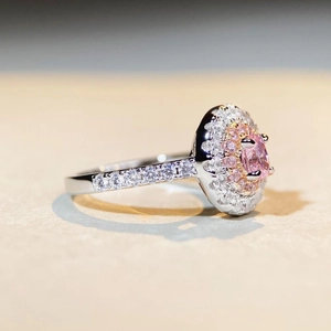 Macro side view of S925 sterling silver ring featuring a pink oval gemstone and halo setting