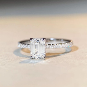 Macro view of emerald cut moissanite ring with S925 silver and side stone accents