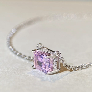 Vue macro d'un pendentif en pierre rose rectangulaire serti de diamants sur chaîne argent