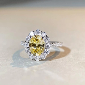 Close-up of luxury S925 silver ring featuring an oval yellow gem with halo diamond setting