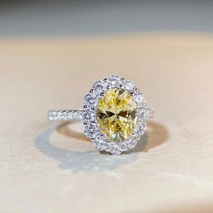 Macro shot of oval yellow gemstone ring with halo diamonds and pavé set silver band