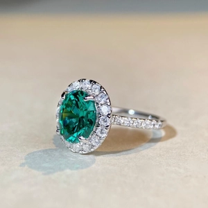 Bague de luxe en argent avec une grande pierre verte ovale et sertissage halo
