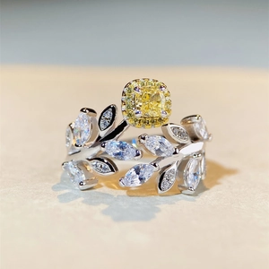 Détail macro d'une bague feuille en argent avec une pierre jaune carrée étincelante