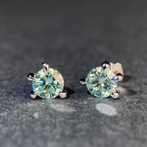 Dettaglio di orecchini a lobo in moissanite scintillante con classica montatura a sei griffe