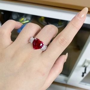 Detail of a heart-shaped red corundum ring in S925 sterling silver worn on a finger