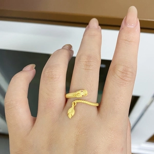 Dettaglio dell'anello a forma di drago dorato con occhi di pietre rosse e squame