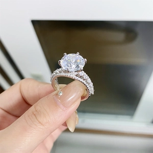 Macro detail of a 5-carat round moissanite ring with pave diamond band on sterling silver