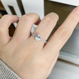 Macro view of pear cut moissanite ring with micro-pave band worn on a finger
