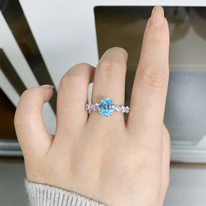 Close-up of S925 sterling silver ring featuring a light blue oval-cut gemstone on a finger