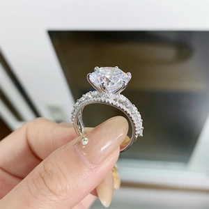 Detailed view of 5ct round moissanite ring with six-prong setting and pavé band
