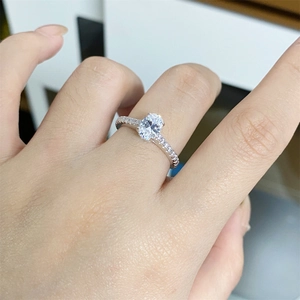 Close-up of S925 silver ring featuring an oval moissanite and pavé set diamond band