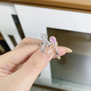 Macro detail of S925 silver bow ring featuring a pink pear-cut stone on a hand
