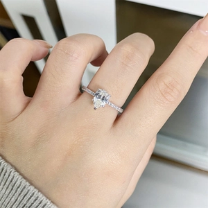 Pear-shaped 1 carat moissanite silver ring with pavé diamond band on hand
