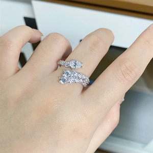 Detail of adjustable silver ring featuring a teardrop diamond and pave setting on hand