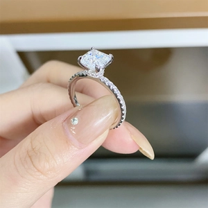 Macro detail of Asscher cut 2ct moissanite ring with four-prong setting and pavé band
