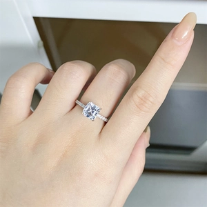 Detailed view of Asscher cut moissanite ring with side stones in classic 4-prong setting