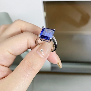 Detail of a rectangular blue tanzanite ring with silver band and side accent diamonds