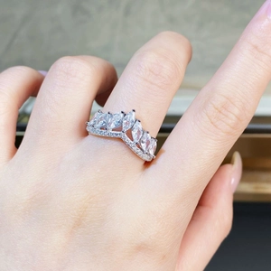 Detail of V-shaped crown ring with marquise-cut stones and pavé set diamonds on hand