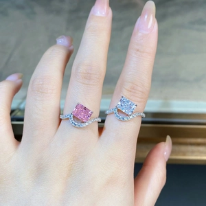 Close-up of radiant cut pink and clear diamond rings with wavy sterling silver bands
