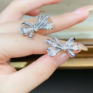 Elegant S925 sterling silver bow earrings with sparkling pavé zircons held in hand