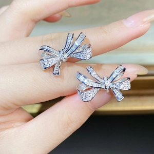 Macro detail of S925 silver bow earrings featuring pavé-set shimmering zircon stones
